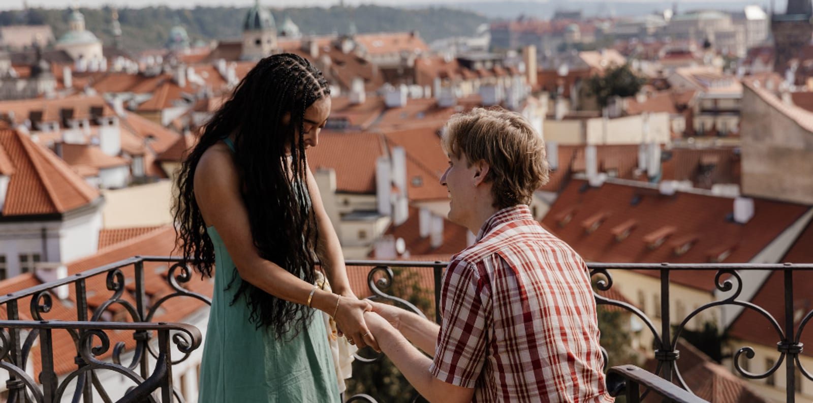 Marriage proposal on one knee over the Vrtba Garden terrace, Prague rooftops behind